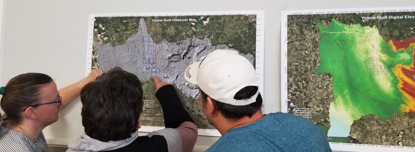 Researchers and Community looking at maps of flooding events